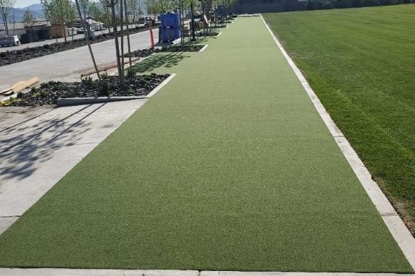 Asheville Outdoor tee line consisting of one continuous green synthetic grass strip surrounded by trees